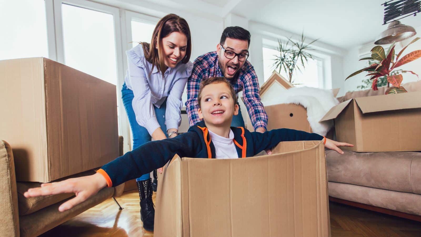 A family packing moving boxes and playing during the process.